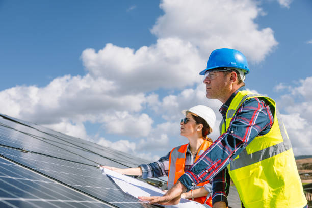 istock Solar Energy Collaboration: Young Woman Engineer and Middle-Aged Maintenance Worker Team Working at Photovoltaic Farm 1883454708