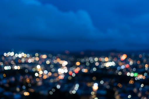 Bokeh and defocused image of illuminated lights and sky at twilight, blurred aerial view of cityscape