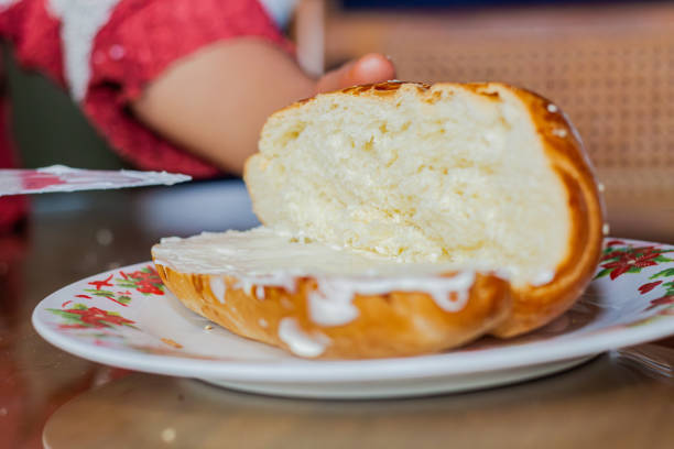 istock baker woman's hand spreading mayonnaise on an open loaf with a knife on a plate at a breakfast table 1883719132