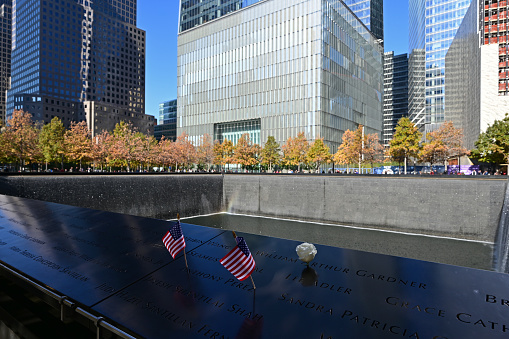 New York, New York - November 6, 2021 - Miniature American flags and flowers commemorate those lost on 911 at World Trade Center Memorial.