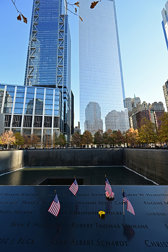 New York, New York - November 6, 2021 - Miniature American flags and flowers commemorate those lost on 911 at World Trade Center Memorial.