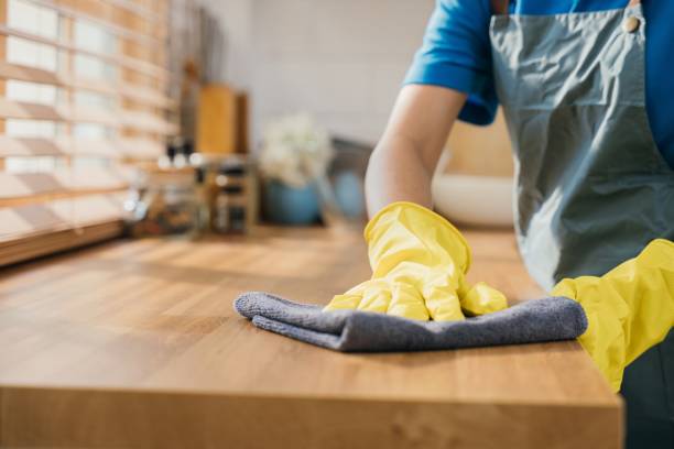 istock Housewife or maid in modern kitchen wipes dining table surface. Using professional cleaning products for home perfect tidiness. Cleaner at work safety glove hygiene routine. Maid housekeeping concept. 1883798999