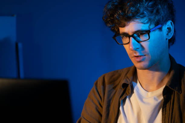 istock Businessman concentrating on pc on project at neon light office. Gusher. 1883814961
