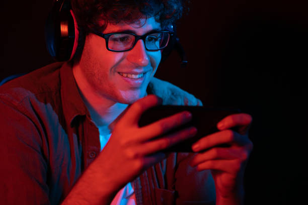 istock Smiling streamer team playing with Esport online on smartphone. Gusher. 1883830214