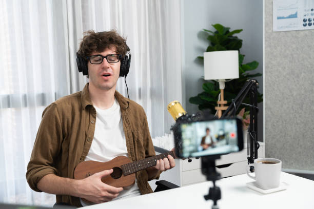 istock Influencer singing with playing guitar on blurred phone with singer. Gusher. 1883848164