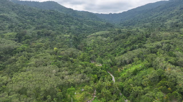 Aerial drone view of Beautiful sky road over top of mountains with green jungle. Road trip on curve road in mountain.
