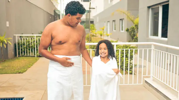 Siblings with towel near the pool