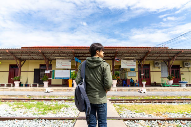 istock Young Asian man walking at railway station. 1883979510