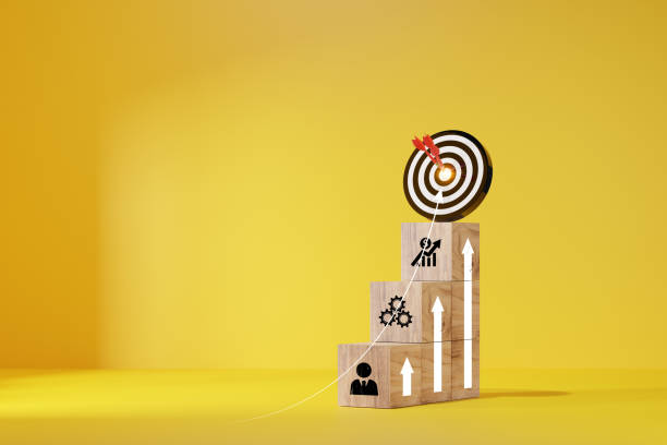 istock woods block step on table with icon Action plan. target icon on the top of wooden cube blocks. Shining rise up arrow shoot up towards the goal, business growth process. 1884023574