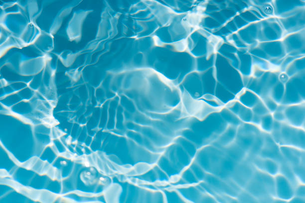 istock Bluewater waves on the surface ripples blurred. Defocus blurred transparent blue colored clear calm water surface texture with splash and bubbles. Water waves with shining pattern texture background. 1884098298