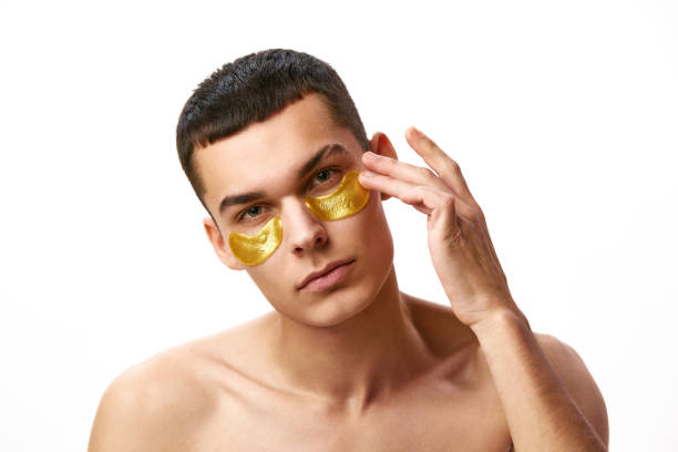 istock Refreshment. Young handsome shirtless man using under eye patches to moisturize under eye area against white studio background 1884156736