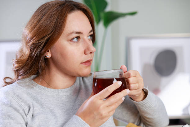 istock Young woman drinking her winter tea at home 1884164449