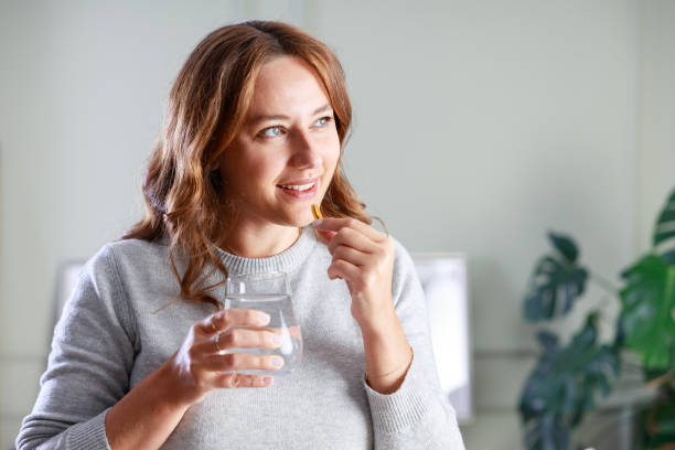 istock Young woman taking Omega 3 capsule 1884165980