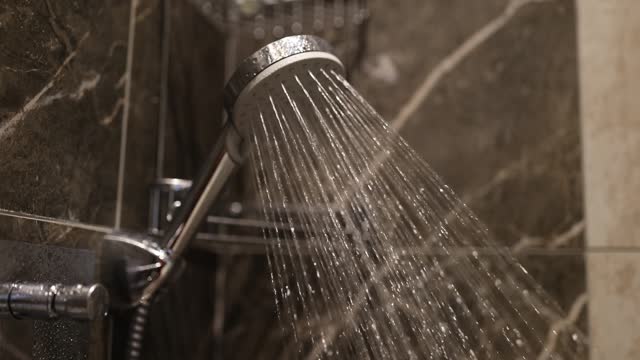 Strong jet of hot water pours from head in shower stall
