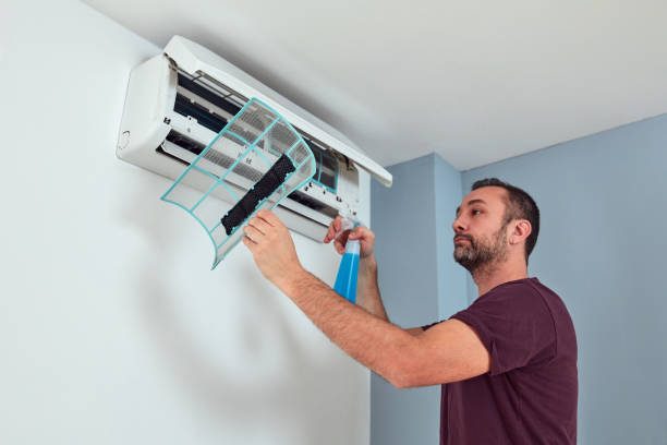 istock Man cleaning and maintaining air condition unit. 1884224797