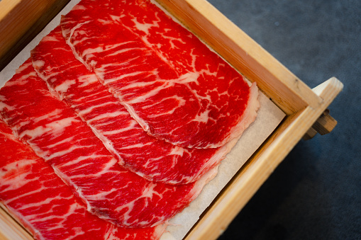 Freshness sliced raw beef served in wood box for Sukiyaki and Shabu.