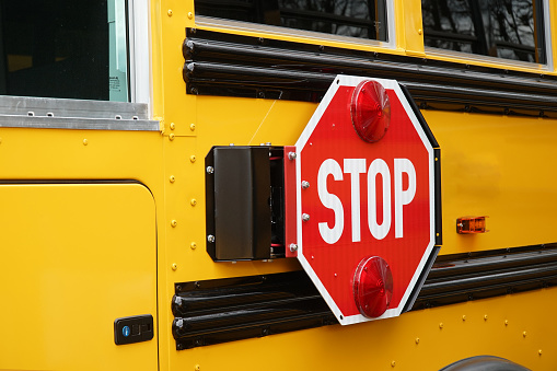 Close up on school bus with stop sign
