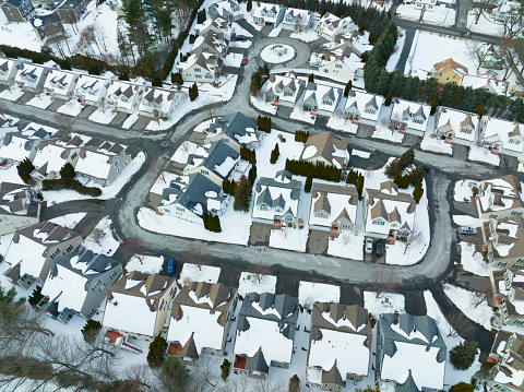 aerial view of residential house and community in winter after snow