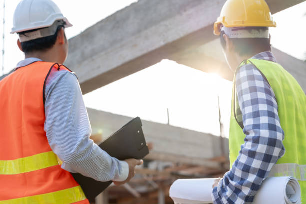 istock Engineers use blueprint check construction on site. Contractor and inspector inspection construction during project.civil Forman check quality assurance. Audit, inspect, quality control. 1884266134