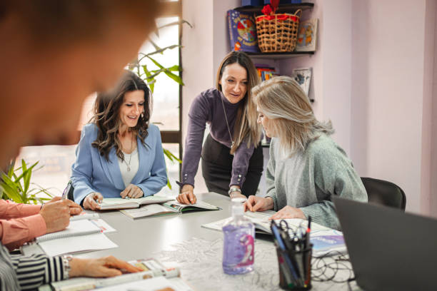 istock Female teacher helping her senior students learn in language school 1884276571