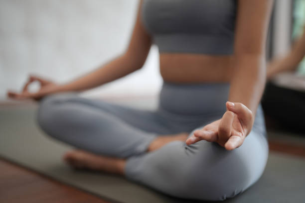 istock Groups of Asian women practicing basic position relaxing meditation on the mat floor at yoga class fitness gym. Young Asian women practice relaxing meditation lotus pose on a yoga mat in a fitness center. 1884346695