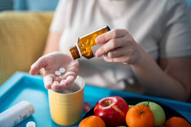 woman taking medicines at home - painkiller thermometer tea prescription medicine imagens e fotografias de stock