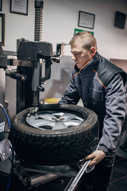 istock Mechanic putting tire on wheel rim 1884376581