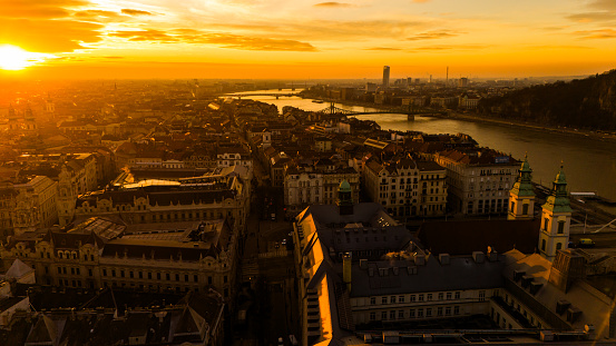 As the Sun Sets,an Aerial Drone Unveils the Mesmerizing Cityscape Along the Danube River in Budapest,Hungary. The Warm Hues of Sunset Cast a Magical Glow Over the Urban Landscape