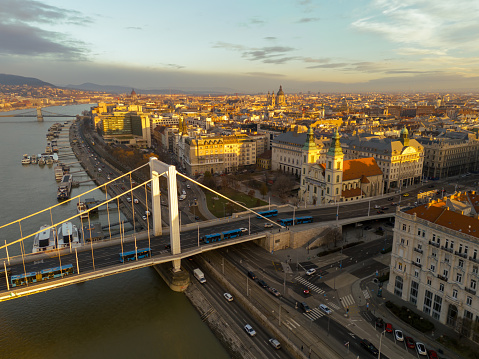 In the Enchanting Glow of Sunset,a High Angle Drone View Captures the Picturesque Scene of the Elisabeth Bridge Elegantly Spanning the Danube River Amidst the Captivating Cityscape of Budapest,Hungary. The Warm Hues of the Setting Sun Cast a Golden Glow Over the Landscape