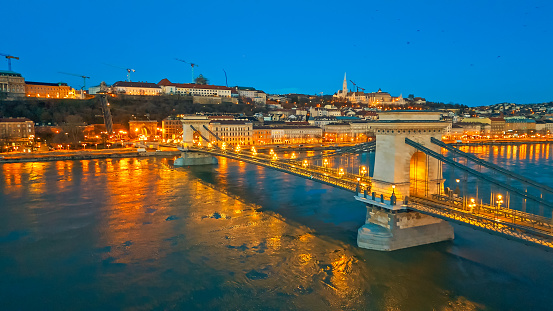 Budapest by Night,an Aerial Drone Captures the Illuminated Szechenyi Chain Bridge Over the Danube River,Surrounded by the Enchanting Cityscape. A Breathtaking Nocturnal View of Budapest,Hungary