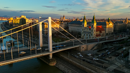 From the Captivating Vantage Point of an Aerial Drone,the Elisabeth Bridge Takes Center Stage on the Historic Cityscape of Budapest,Hungary,During the Enchanting Moments of Sunset. The Warm Tones of the Fading Sunlight Cast a Golden Glow Over the Architectural Beauty of the Bridge