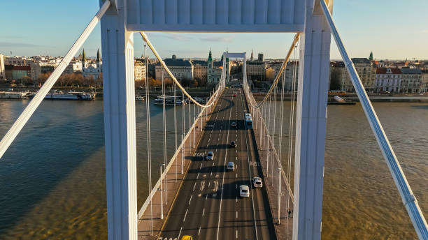 Sunny Day Commute,a High Angle Drone View Captures the Flow of Vehicles on the Elisabeth Bridge Over the Danube River in Budapest,Hungary. The Scene is Bathed in Sunlight,Showcasing the City's Bustling Energy and Scenic Charm