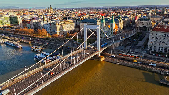 Sunny Day Panorama,a High Angle Drone View Captures the Elisabeth Bridge Gracefully Spanning the Danube River Amidst the Vibrant Cityscape of Budapest. A Picturesque Scene Bathed in Sunlight