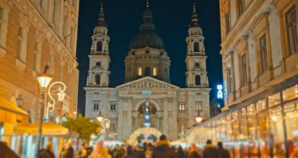 Nighttime Splendor,St. Stephen's Basilica Adorned with Festive Lights,Hosting a Christmas Market with Lively People in Budapest,Hungary. The Enchanting Scene Captures the Magical Ambiance of the Holiday Season