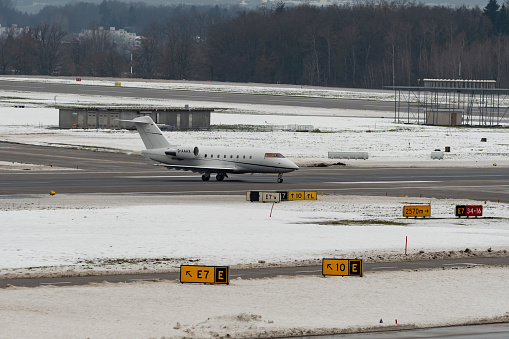 Zurich, Switzerland, December 6, 2023 D-AAAX Bombardier Challenger 604 aircraft is taxiing to its takeoff position in the winter time