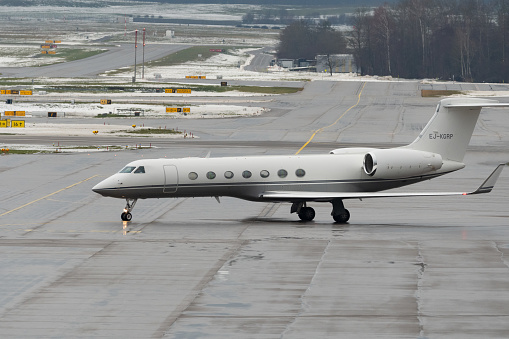 Zurich, Switzerland, December 6, 2023 EJ-KGRP Gulfstream G550 aircraft is taxiing on the apron in the winter time