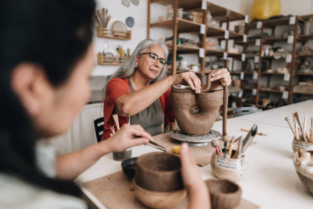 Senior woman making a craft product on a ceramics workshop