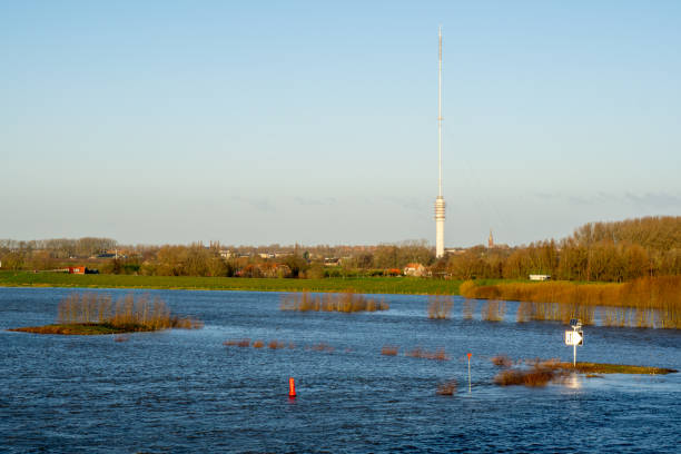 Very high water level in the river Lek near Nieuwegein with the transmission tower in Lopik in the background near the village of IJsselstein, Utrecht, the Netherlands Very high water level in the river Lek near Nieuwegein with the transmission tower in Lopik in the background near the village of IJsselstein, Utrecht, the Netherlands lek river in the netherlands stock pictures, royalty-free photos & images