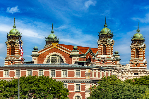 Photograph of the Ellis Island Immigration Museum under a beautiful blue sky, typical of the Big Apple and Manhattan.