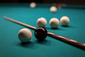 Billiard balls on green billiard table with shallow depth of field