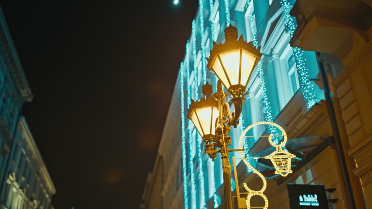 Low Angle Handheld Shot of Illuminated Lamp Post and Building During Christmas Against Sky at Night in Budapest,Hungary