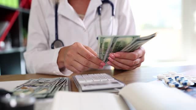 Doctor counting money with calculator in clinic closeup 4k movie slow motion