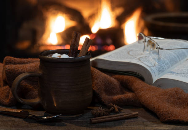 istock Mug of hot chocolate with fireplace burning in background 1884691887