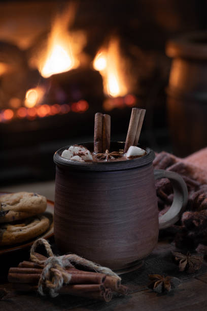 istock Mug of hot chocolate with fireplace burning in background 1884691889