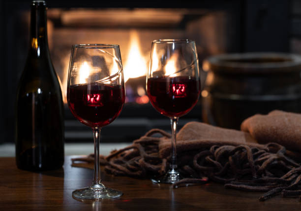 istock Two glasses of wine with fireplace in background 1884693478