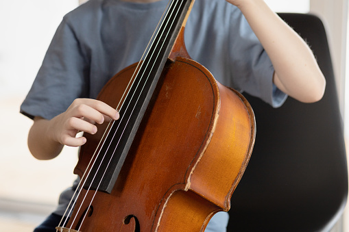 6 year old boy playing cello at home