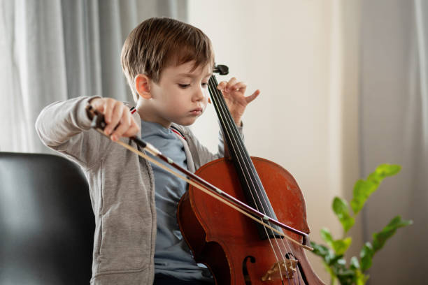 istock 6 year old boy playing cello at home 1884735797