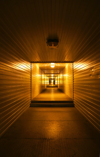 Long metal tunnel or passage, warm light
