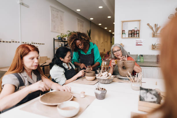 istock Pottery teacher teaching her student at a ceramics workshop 1884766189