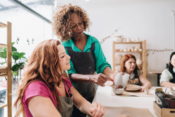 istock Pottery teacher teaching her student at a ceramics workshop 1884766192